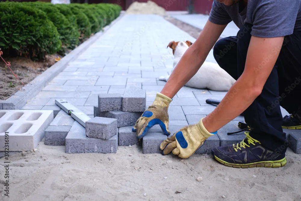 Garden brick pathway paving by professional paver worker