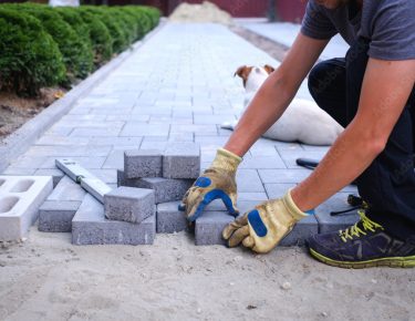 Garden brick pathway paving by professional paver worker