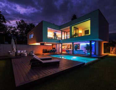 Modern villa with colored led lights at night.