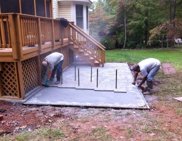 professionals stamping concrete in the backyard