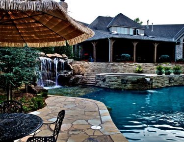 stone paved side pool patio and backyard fountain